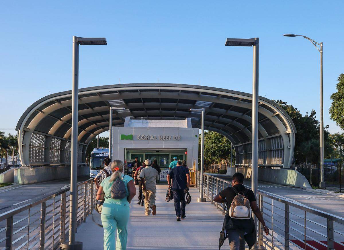 Bus commuters rush to the Coral Reef Station (152nd Street Station) after standing at the local 52 bus stop to later scurry to board the Metro Express on the first day of Miami-Dade's $300 million rapid-transit bus line known as “Metro Express” on Monday, October 27, 2025, just west of Richmond Heights on Coral Reef Drive and U.S. 1. Many first day riders complained about crowded buses and long travel times due to red lights on the express lane.