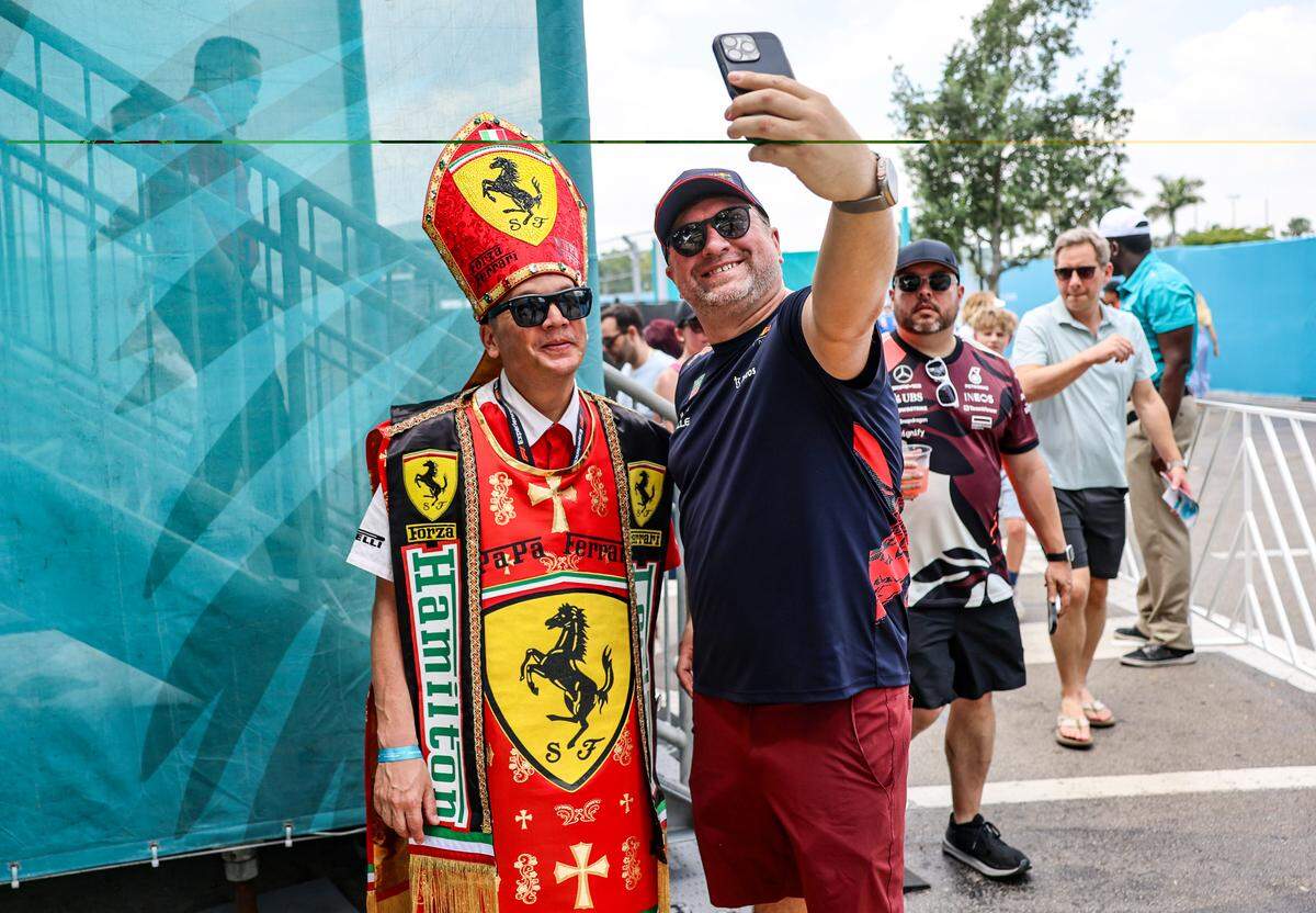 A Lewis Hamilton fan, left, dresses in “Papa Ferrari” outfit stops for a quick selfie after the Sprint Race on the second day of the Formula One Miami Grand Prix at the Miami International Autodrome on Saturday, May 2, 2026, in Miami Gardens, Fla.