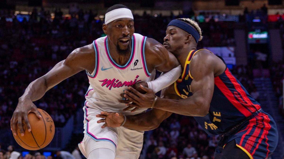Miami Heat center Bam Adebayo (13) drives on Golden State Warriors forward Jimmy Butler III (10) during the second half of an NBA game at Kaseya Center on March 25, 2025, in Miami.