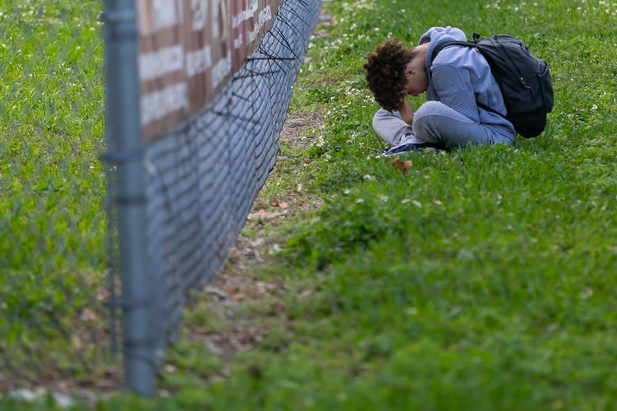 Visitors gather near a makeshift memorial outside Marjory Stoneman Douglas High School on Friday, Feb. 14, 2020, during the two-year anniversary of the Parkland shooting where 17 were killed.