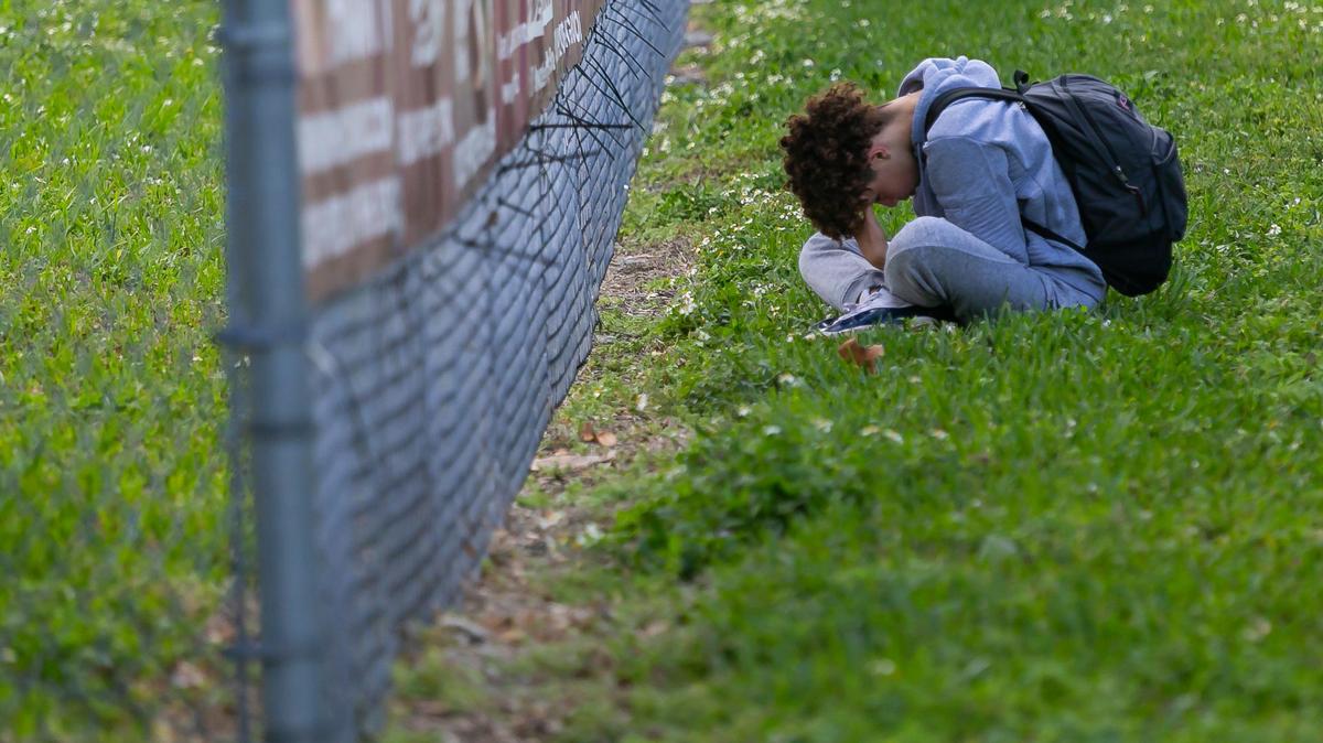 A visitor near a makeshift memorial outside Marjory Stoneman Douglas High School on Feb. 14, 2020, observing the two-year anniversary of the Parkland shooting in which 17 were killed.