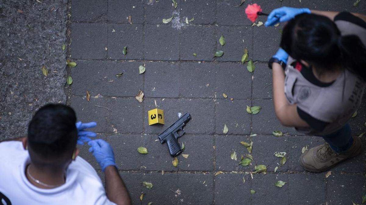 Mexican forensic experts examine a gun used in an assault in the La Condesa neighborhood of Mexico City last year.