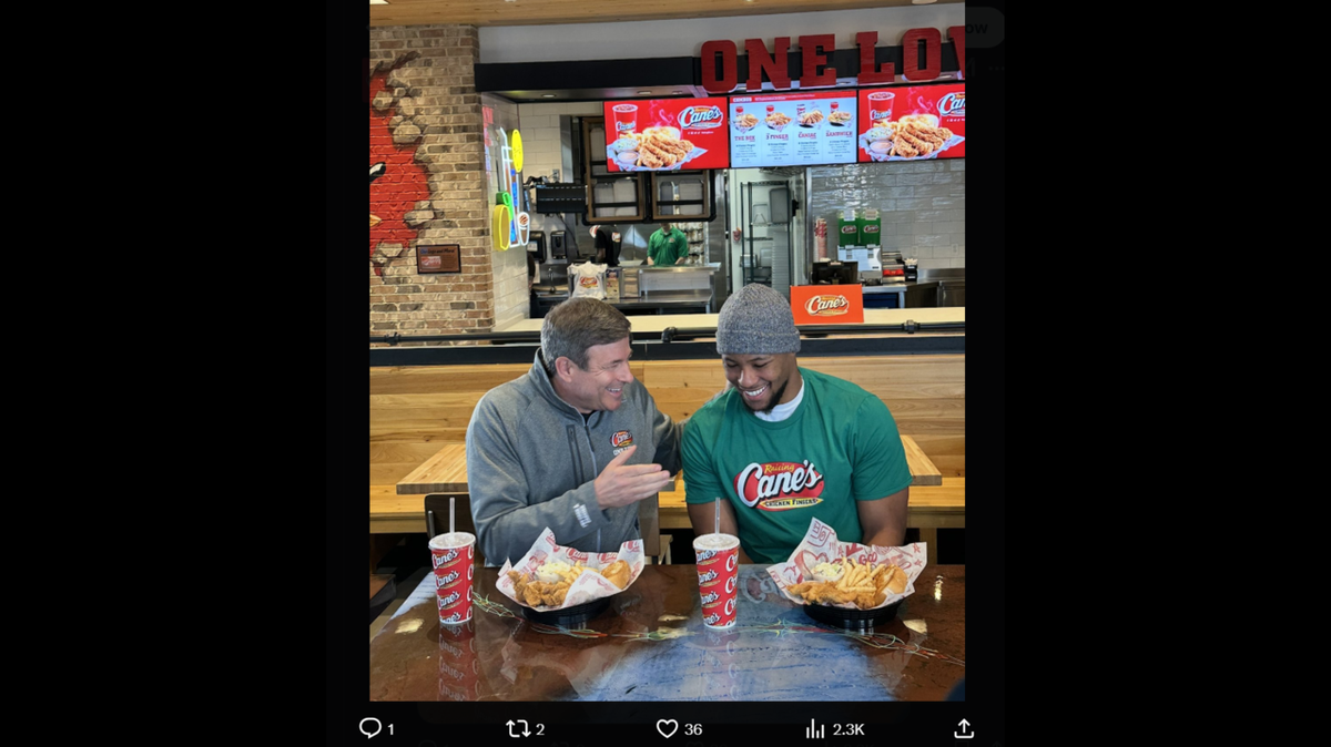 Raising Cane’s CEO Todd Graves gets a bite with Philadelphia Eagles running back Saquon Barkley on Feb. 13. Barkley greeted fans and worked a shift at a Pennsylvania Cane’s location.