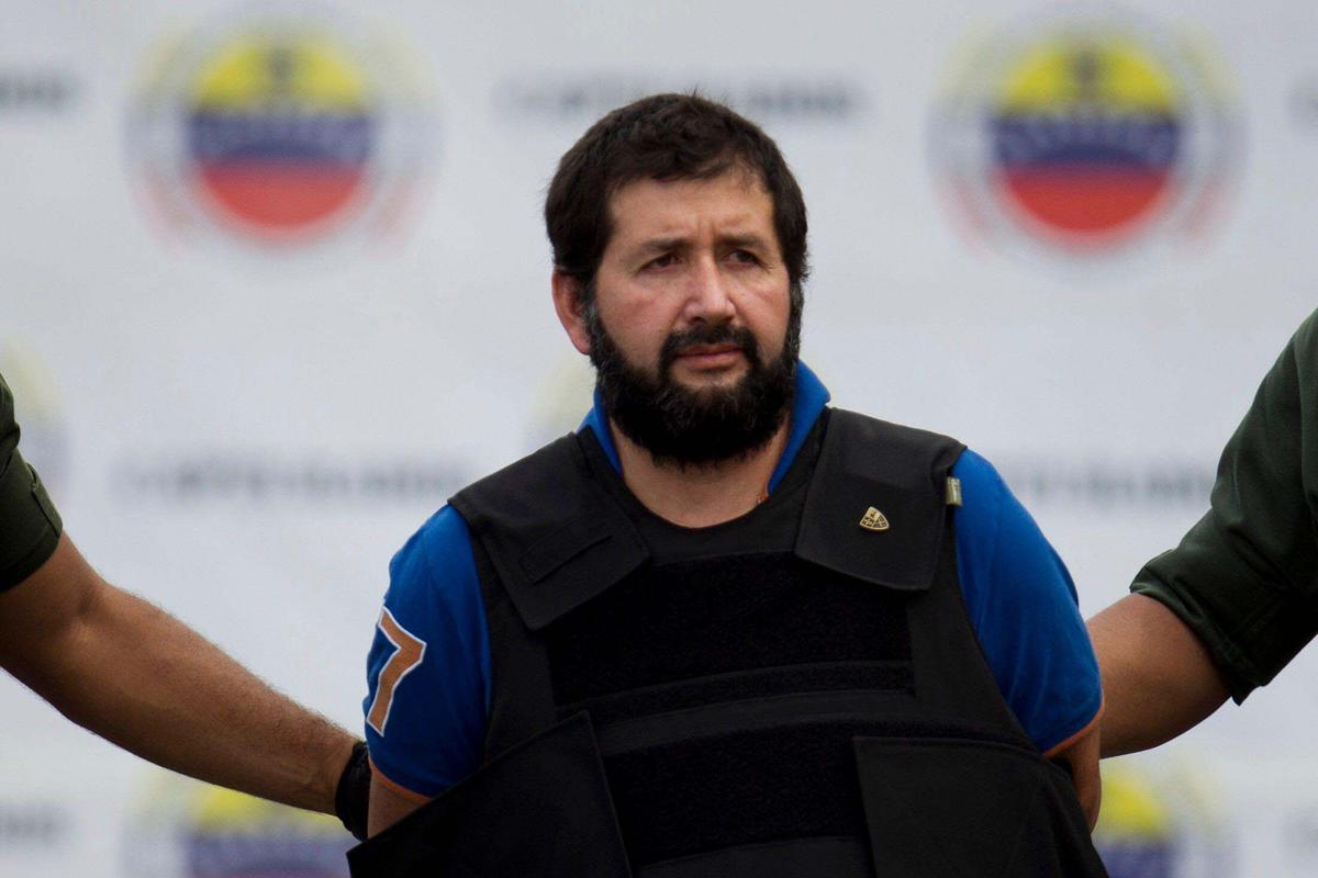 Daniel ‘El Loco’ Barrera, one of Colombia’s most wanted drug traffickers, is escorted by police officers during his extradition at Simon Bolivar Airport in Caracas on Nov. 14, 2012.