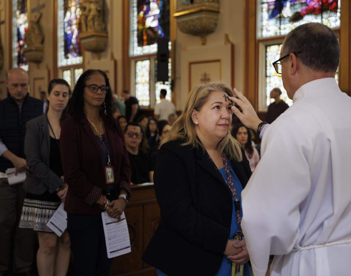 A parishioner receives ashes from a Deacon during Ash Wednesday mass on Wednesday, Feb. 18, 2026, at Gesu Catholic Church in downtown Miami. The mass was fully packed with standing room only at the back of the church. 
