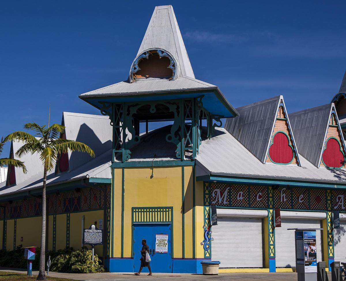 A pedestrian walks past the shuttered Caribbean Marketplace in Little Haiti on April 1, 2020.