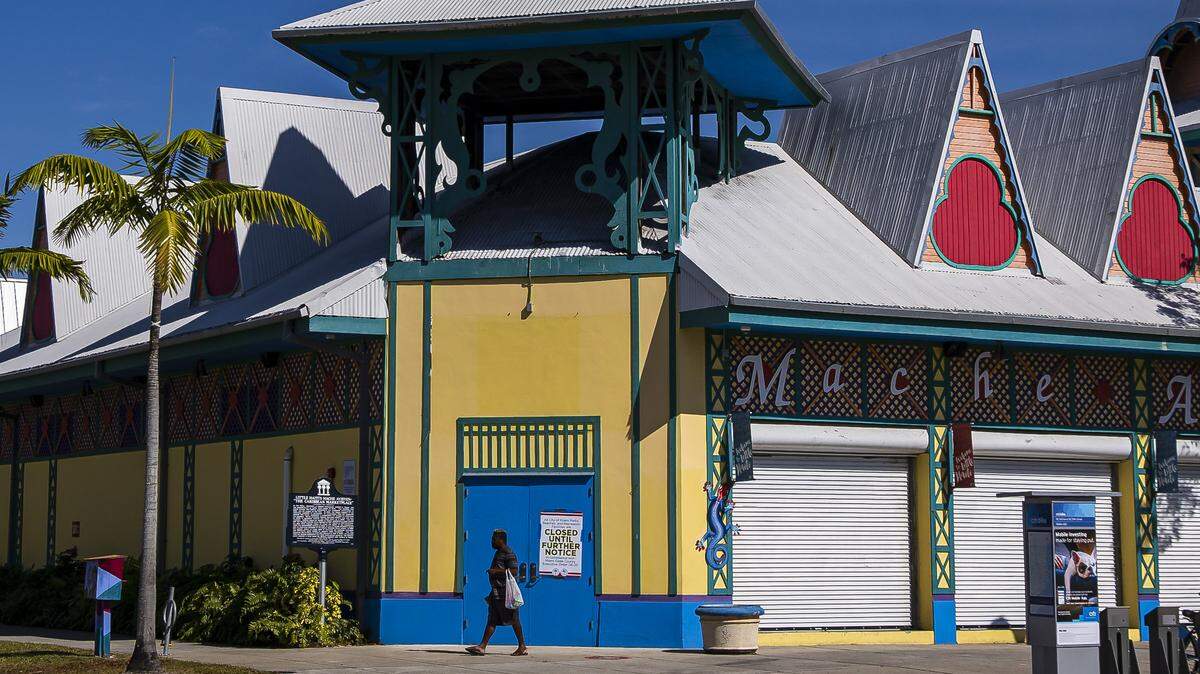 A pedestrian walks past the shuttered Caribbean Marketplace in Little Haiti on April 1, 2020.