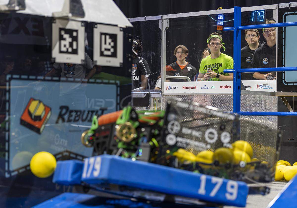 Suncoast Community High School students Jason Pitchford, 18, center, in green, and C.J. Crawford, 17, far right, drive their team’s robot, SwampThing, as they compete in the 2026 FIRST Robotics South Florida Regional Competition at the University of Miami’s Watsco Center on Friday, April 10, 2026, in Coral Gables, Fla. Participants from local school districts, surrounding states, and international teams are competing for an opportunity to earn a spot at the 2026 FIRST World Championship.