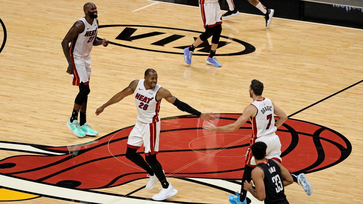 El armador del Heat, Goran Dragic (7), es felicitado por Andre Iguodala (28), en presencia de Dewayne Dedmon en el juego ante los Rockets el 19 de abril de 2021 en el AmericanAirlines Arena.