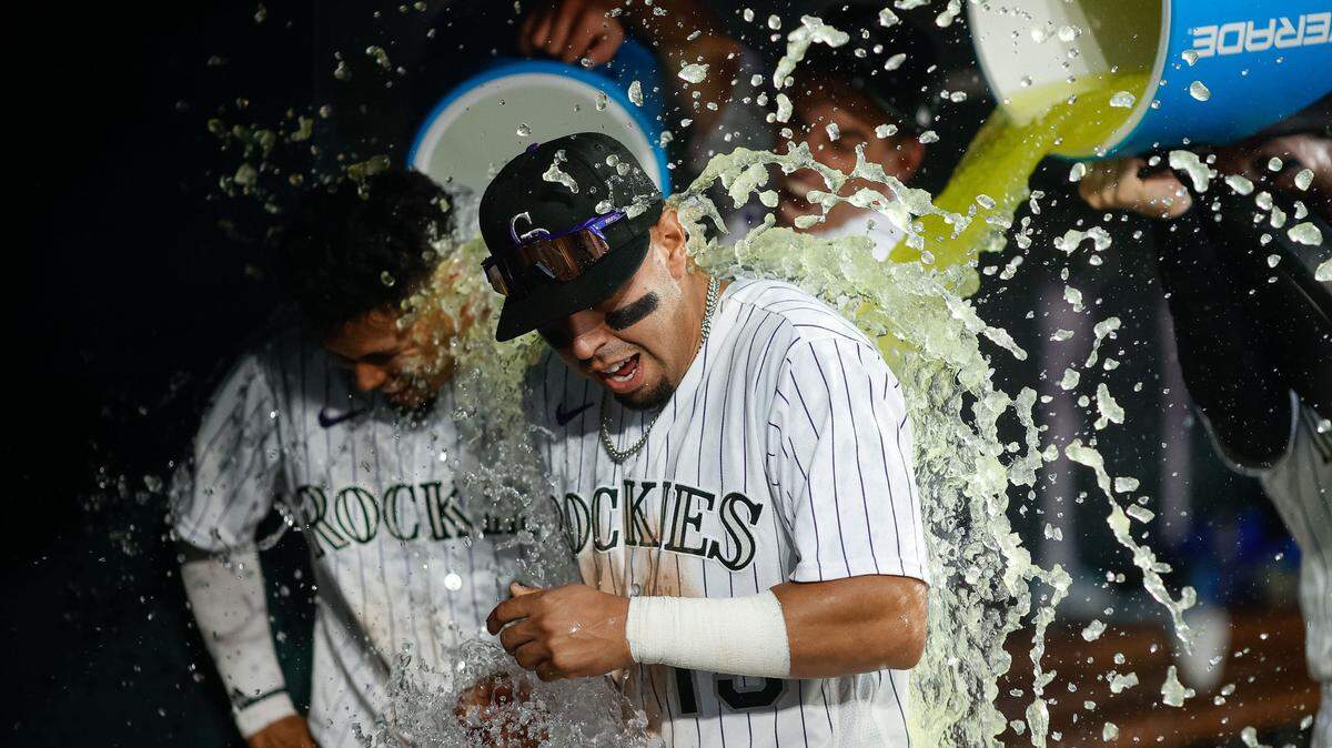 Colorado Rockies second baseman Alan Trejo (13) and Colorado Rockies shortstop Ezequiel Tovar (14) get doused with powerade after the game against the Miami Marlins at Coors Field on Thursday, May 25, 2023.