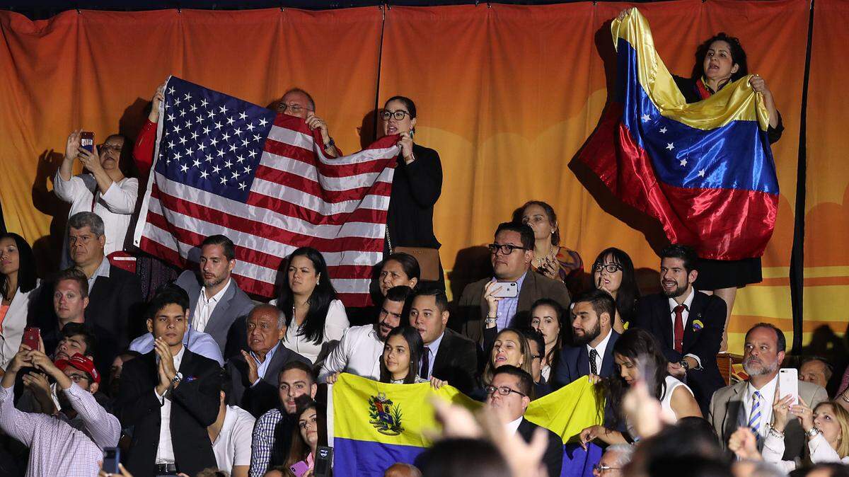 People listen as President Trump speaks during a rally in 2019 at Florida International University in Miami. He addressed the crisis in Venezuela, but never approved TPS for exiles.