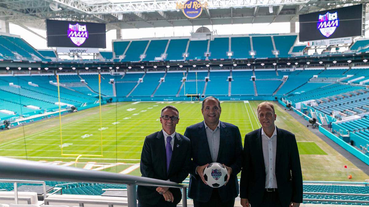 José Sotolongo, de la Oficina de Visitantes del Gran Miami, Víctor Montagliani, vicepresidente de la FIFA y presidente de CONCACAF, y Colin Smith, Director de Torneos y Eventos de la FIFA (de izq. a der.), posan en el Hard Rock Stadium en Miami Gardens, Florida, durante su recorrido por la ciudad de las posibles sedes anfitrionas de la Copa Mundial de la FIFA 2026.