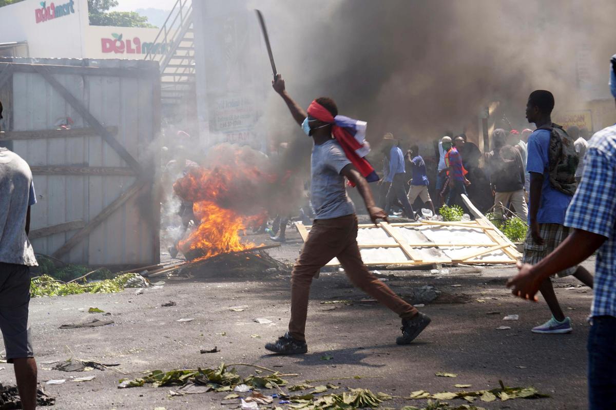 A masked protester wields a machete during a protest in Port-au-Prince, Haiti, Friday, Sept. 27, 2019. Thousands of protesters attacked businesses and government buildings across Haiti Friday, creating chaos on the streets after a weeks-long shutdown of vital services that has damaged the country’s ailing economy and shaken the already tenuous position of Haitian President Jovenel Moïse.