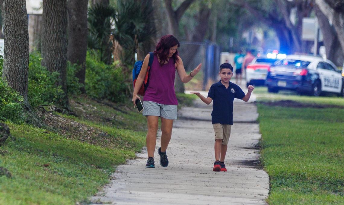 Waleska Cordero high-fives her son Ian Velez, 9, as they head to Bob Graham Education Center in Miami Lakes on the first day of school on Thursday, Aug. 17, 2023.