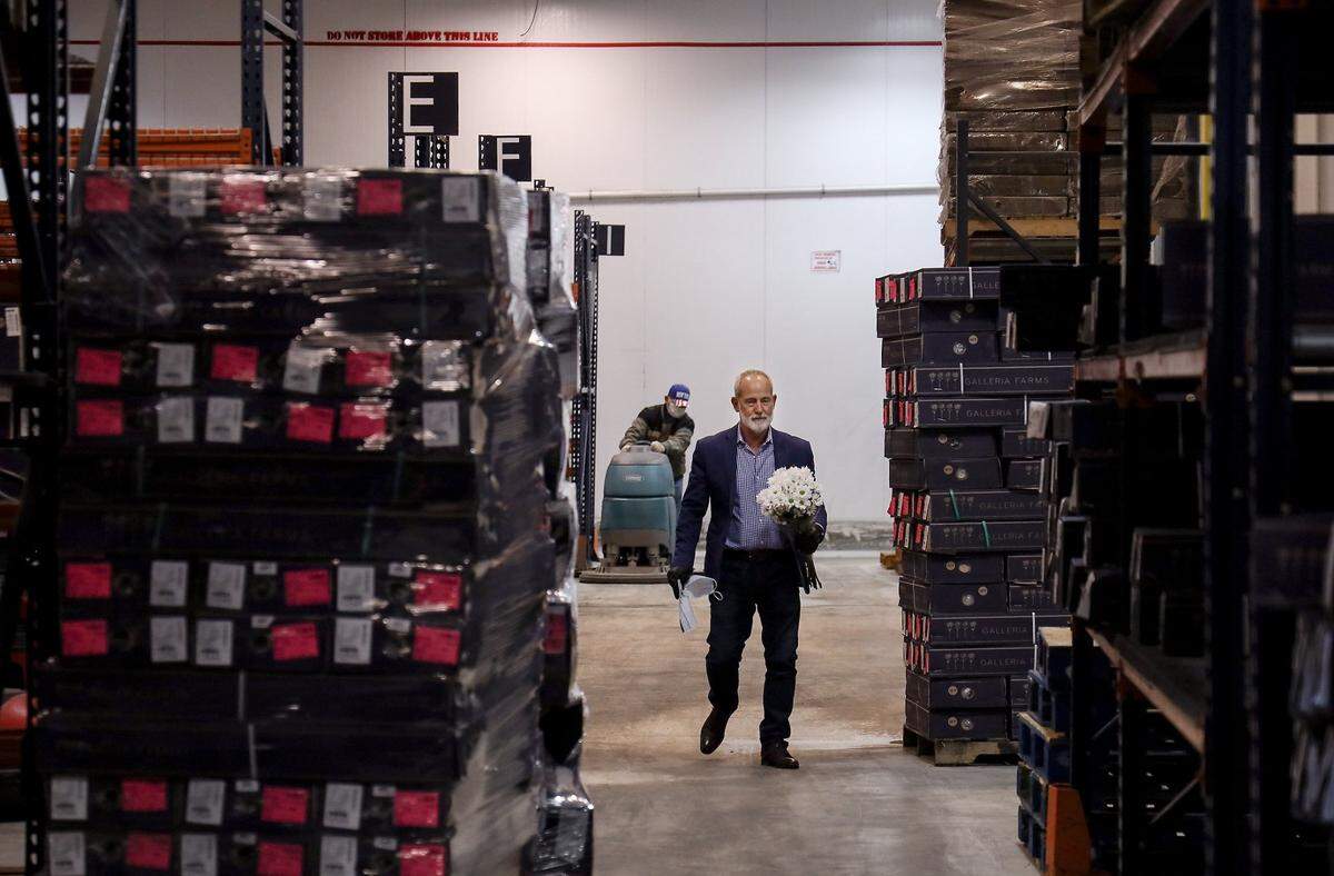 Neil Gold, executive vice president, retrieves some flowers inside the freezer warehouse of Galleria Farms in Doral.