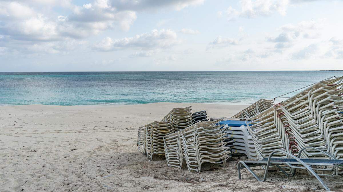 Lounge chairs sit stacked on a beach while temporarily closed in Nassau, Bahamas in April 2020 because of the sudden stop in global tourism as the coronavirus pandemic raged.
