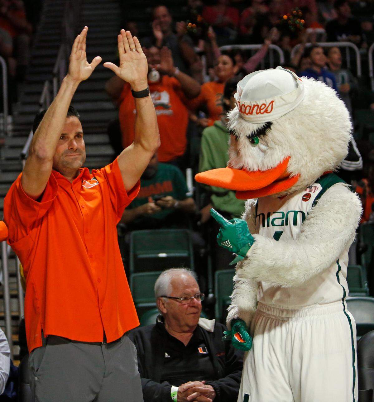 University of Miami football head coach Manny Diaz greets the fans alongside Sebastian the Ibis during the first half of an NCAA college basketball game between the Miami Hurricanes against the NC State Wolfpack at the Watsco Center in Coral Gables on Thursday, January 3, 2019