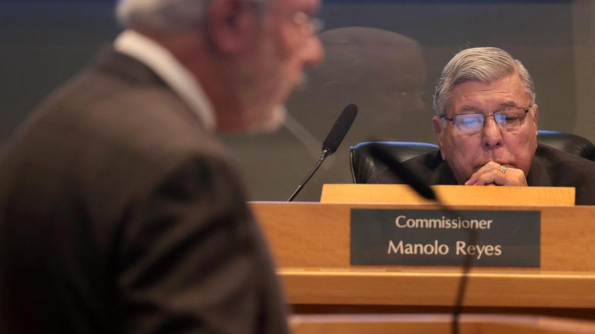 El comisionado Manolo Reyes escucha a Miguel De Grandy, abogado y asesor del bufete Holland & Knight, mientras presenta el plan preliminar de modificación de distritos durante una reunión especial de la Comisión en el Ayuntamiento el 7 de febrero de 2022.
