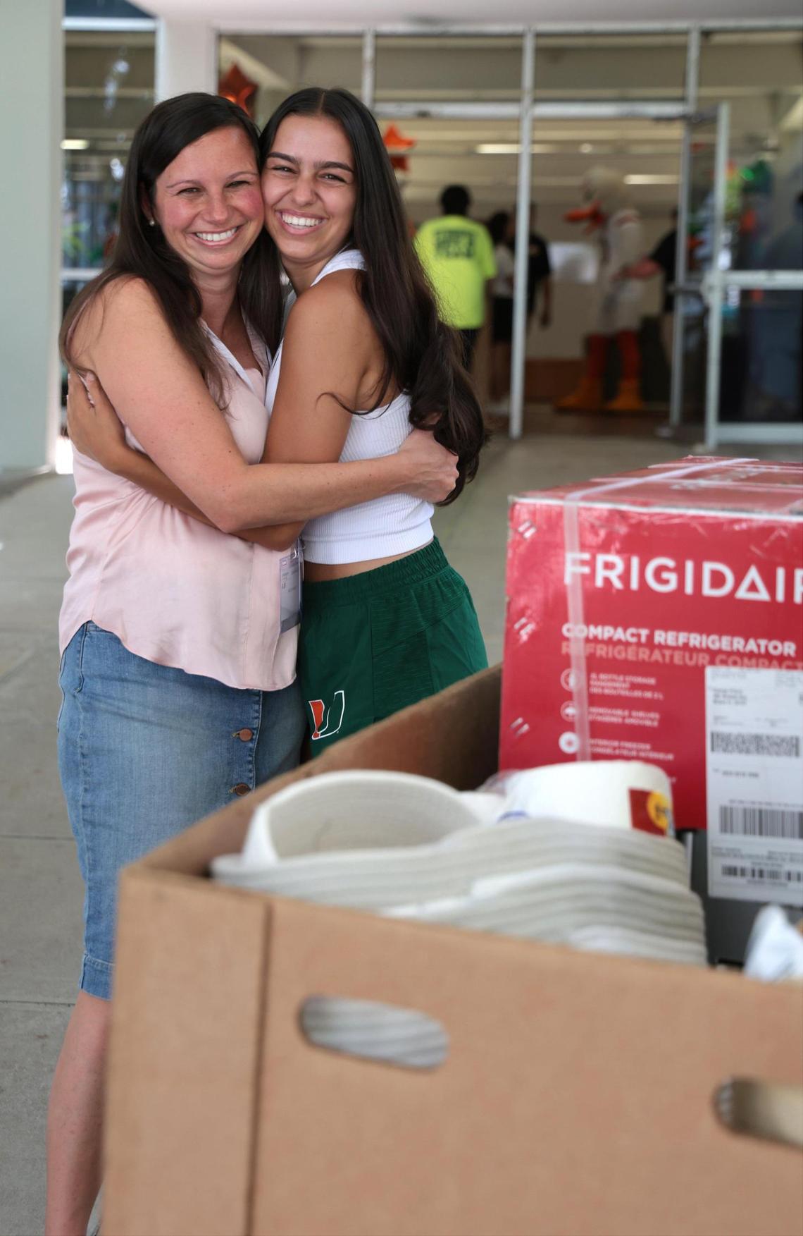 Freshman Ava Prinzo, 17, right, shows her excitement as her belongings are carted to her dorm room while her mother, Kristi Prinzo, right, from New Jersey, hugs her daughter. On Tuesday, Aug. 16, 2022 out-of-state University of Miami freshmen moved into the Mahoney and Pearson residential colleges with help from the “Student Move in Team” in Coral Gables, Florida.