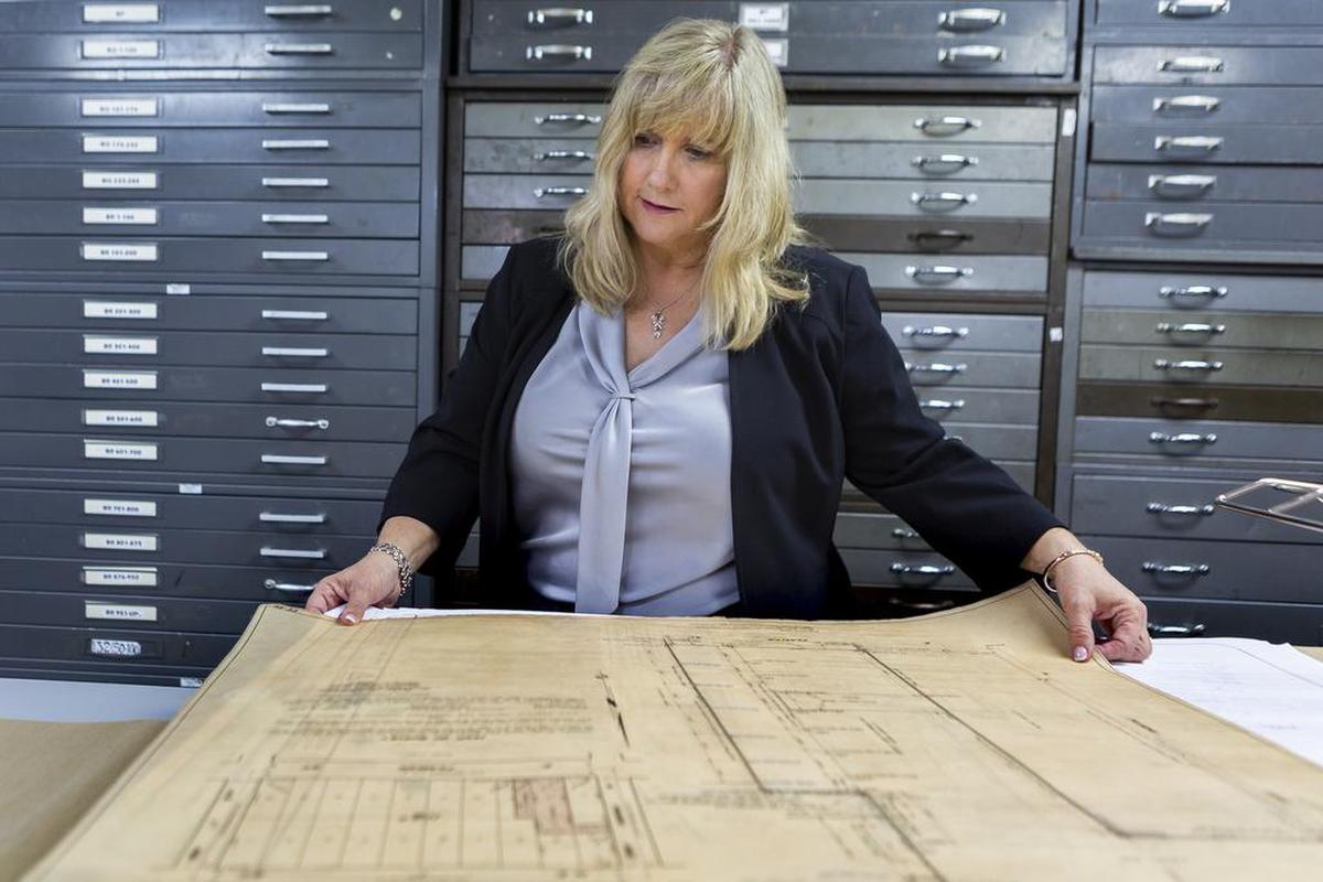 Melissa Bolton Calabrese, the company’s CEO, looks at original survey drawings of South Florida.
