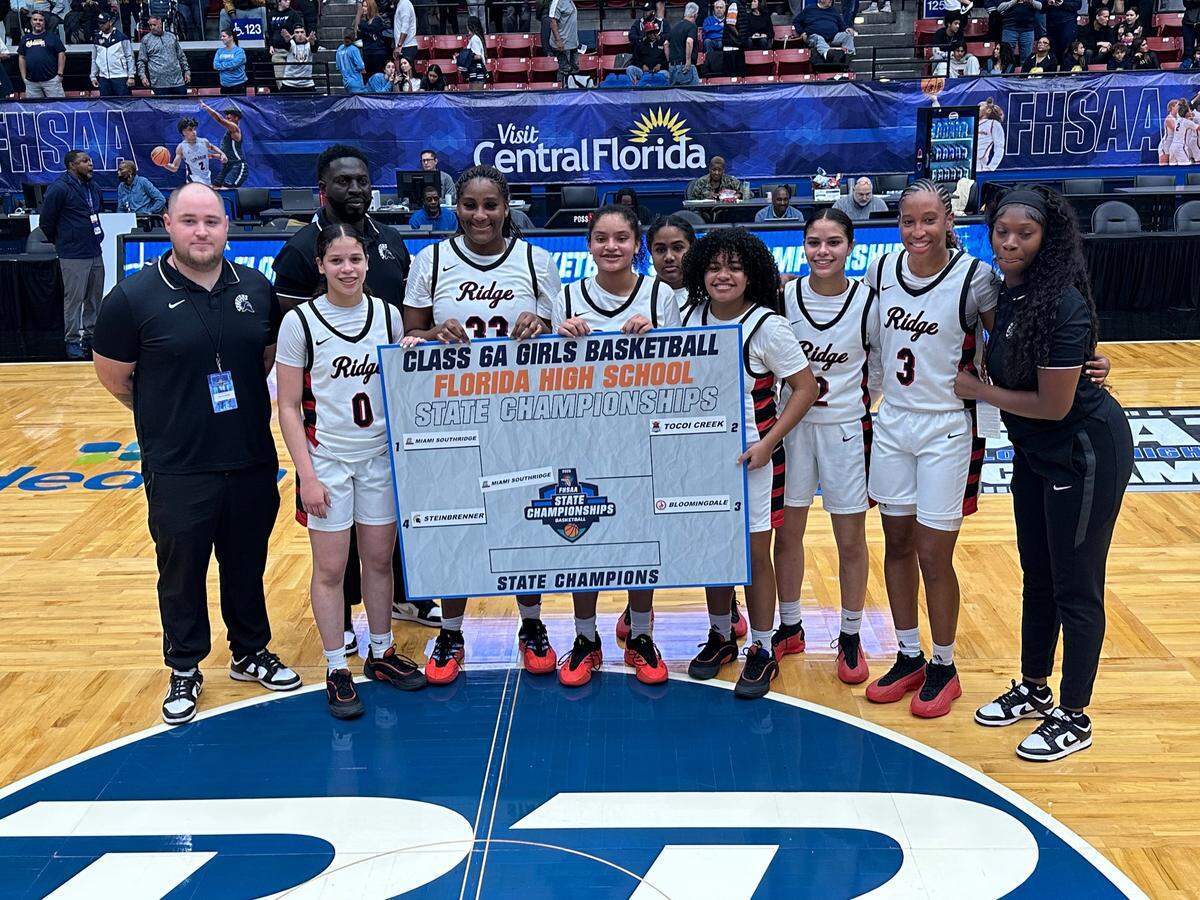 Southridge’s seven-player girls’ basketball team flanked by head coach Nicholas Rodriguez (left) and assistant coach Stephasia Doctor (right).