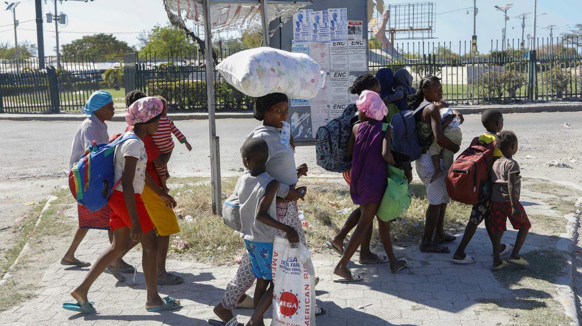 People flee their homes in Cite Soleil due to gang violence as they walk to a police station in Port-au-Prince, Haiti, Monday, Feb. 12, 2024. (AP Photo/Odelyn Joseph)