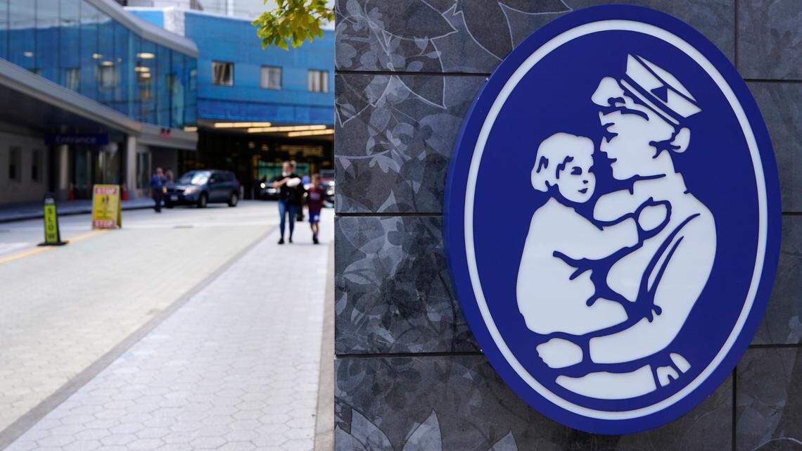 The logo of a nurse holding a child hangs on a wall outside the Boston Children’s Hospital, Thursday, Aug. 18, 2022, in Boston.