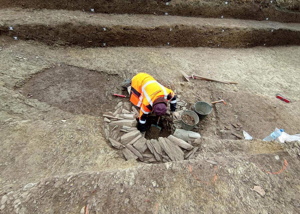 Archaeologists excavate a well.