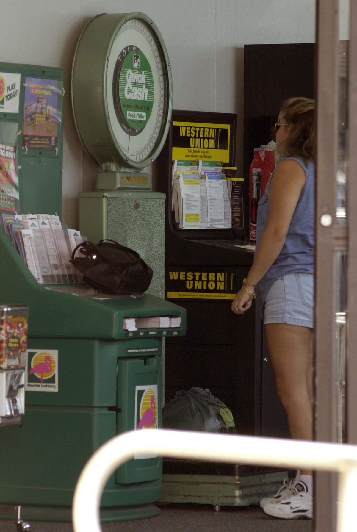 In this file photo from June 22, 2001, a customer weighed a small bag of clothing at a Publix at 13890 SW 56th St. She planned to send the clothes to Cuba with someone who was traveling there. It weighed five pounds. Airlines were cracking down on weight restrictions. Publix considered removing the scales from Miami-area stores at the time as heavy baggage was damaging them.