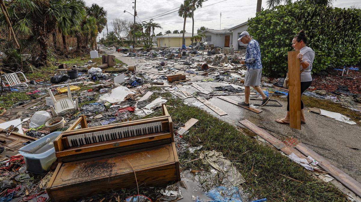 Karre Willis and her husband walk through their neighborhood inspecting the damage and debris in front of their neighbors’ homes in Charlotte County, near Manasota Key, on Thursday, Oct. 10, 2024, the morning after Hurricane Milton hit the area.