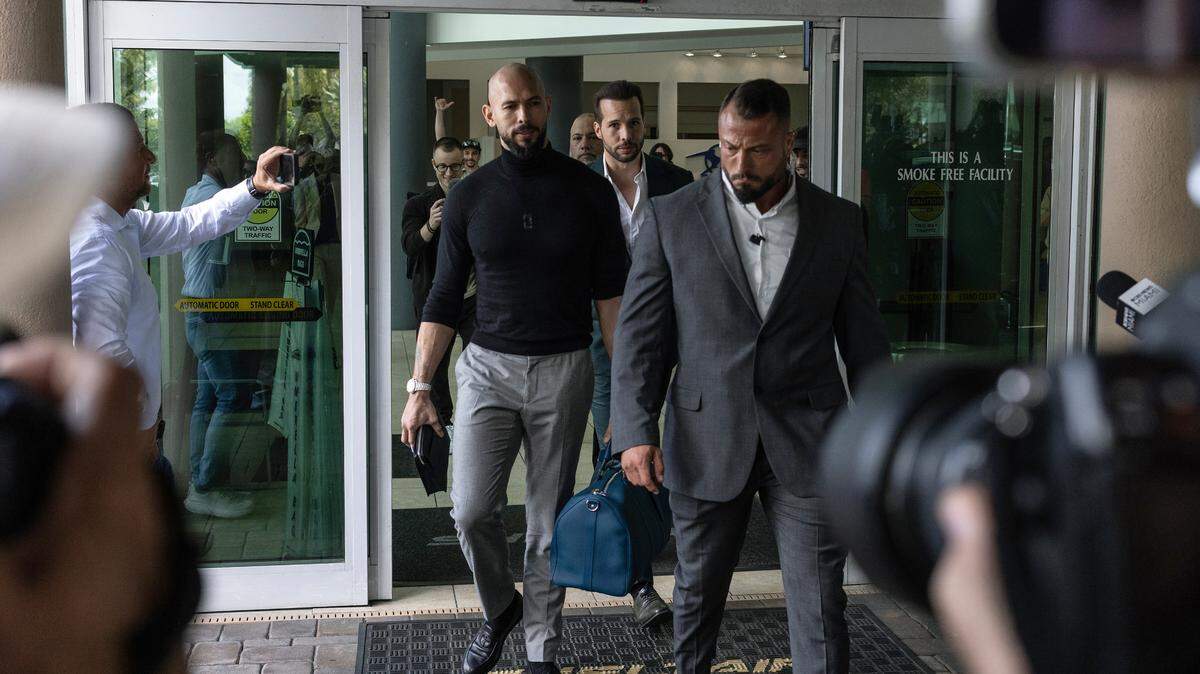 Andrew Tate (L) and Tristan Tate (R) arrive in the United States after a travel ban on them was lifted, at the Fort Lauderdale-Hollywood International Airport on February 27, 2025 in Fort Lauderdale, Florida. The influencer brothers were arrested in late 2022 and charged with human trafficking, alleging that they participated in a criminal ring that lured women to Romania, where they were sexually exploited. Andrew Tate was also charged with rape.