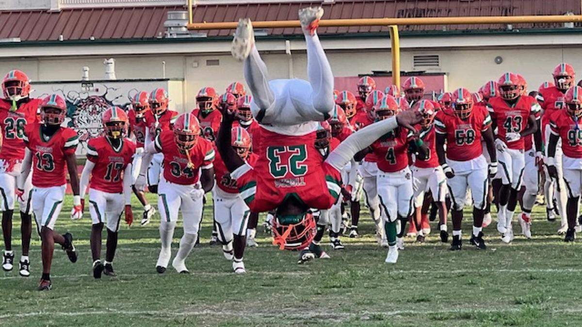 Blanche Ely junior running back Louis Kenson does a forward flip as his team enters the field prior to the opening kickoff of Friday’s game against Chaminade-Madonna. The Tigers beat the Lions 35-34 in overtime.