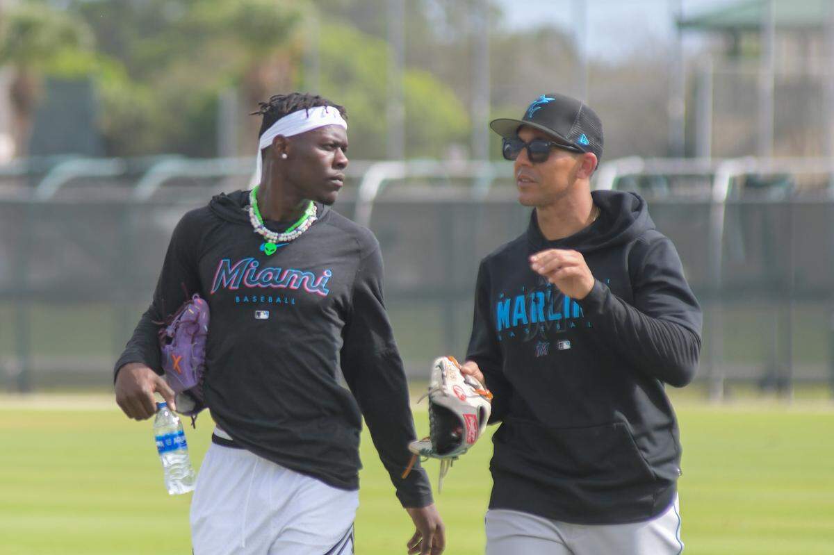 Miami Marlins center fielder Jazz Chisholm Jr. talks with outfielders coach Jon Jay on Feb. 17, 2023, during a spring training workout at the Roger Dean Chevrolet Stadium complex in Jupiter, Florida.