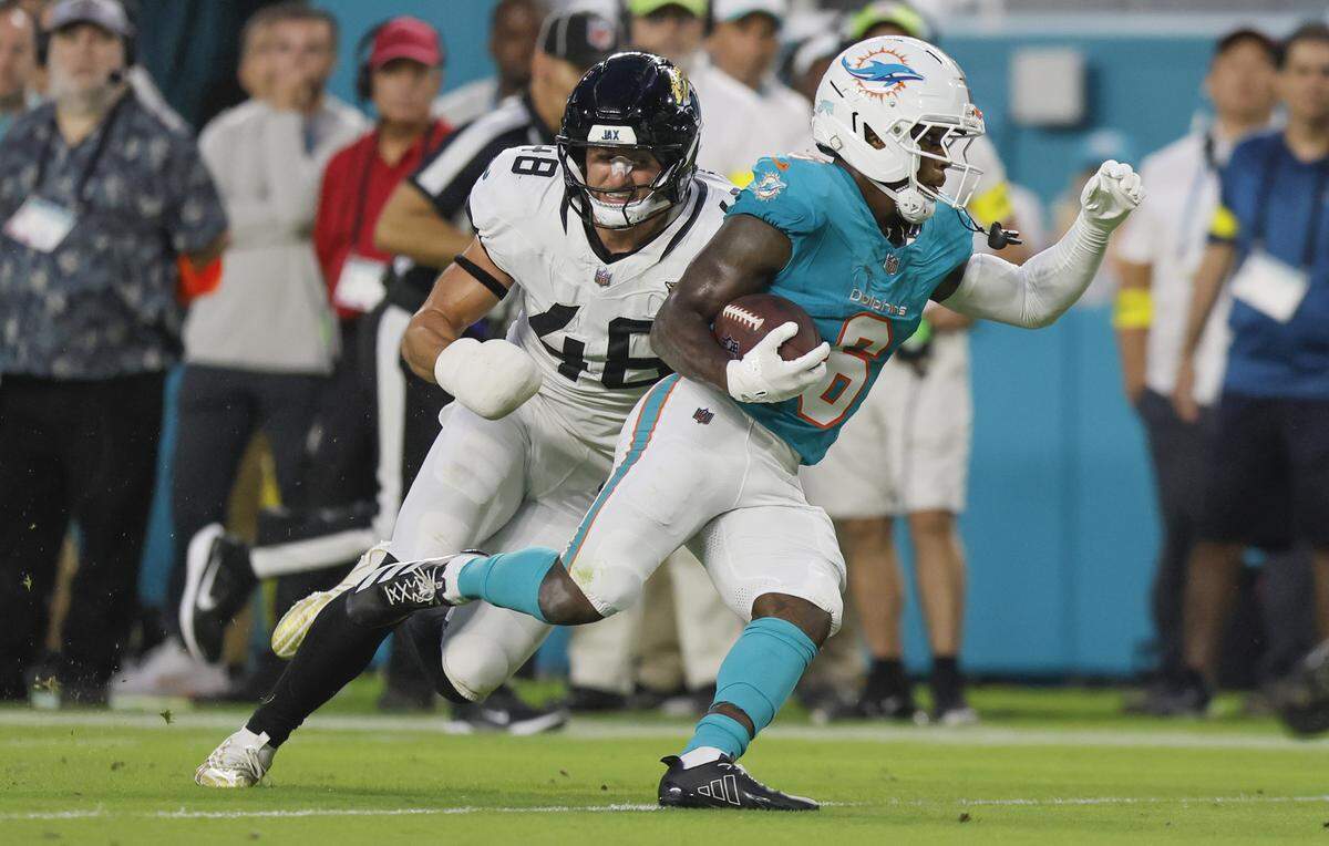 Miami Dolphins wide receiver Malik Washington (6) carries for a touchdown as Jacksonville Jaguars linebacker Chad Muma (48) gives chase in the first half during an NFL football game at Hard Rock Stadium in Miami Gardens, Florida, on Saturday, August 23, 2025.