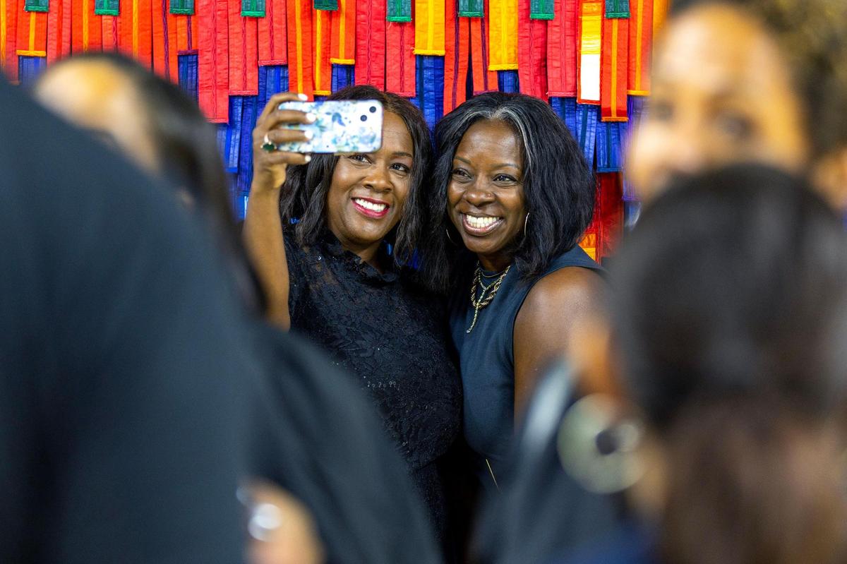 Martha Whisby Wells, left, and Imani Greene, right, take a selfie in front of a textile sculpture by artist Abdoulaye Konaté during the Preview for The Art of Transformation event at The ARC and Logan Building in Opa-locka, Florida, on Wednesday, November 30, 2022. The event is a five-day, three-block Mecca of African and Haitian art fair coinciding with Art Basel Miami Beach 2022 and just one of over 40 ‘exhibits’ part of 2022 Art of Black Miami.