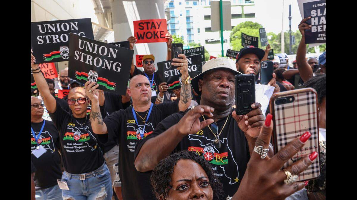Members of Teamsters National Black Caucus listen to Dr. Marvin Dunn, state Rep. Justin Pearson (D-Tenn.), and others outside the Miami-Dade County Public Schools administration building in Miami on Aug. 16. The protest was against the new African American history standards that the state of Florida has approved.