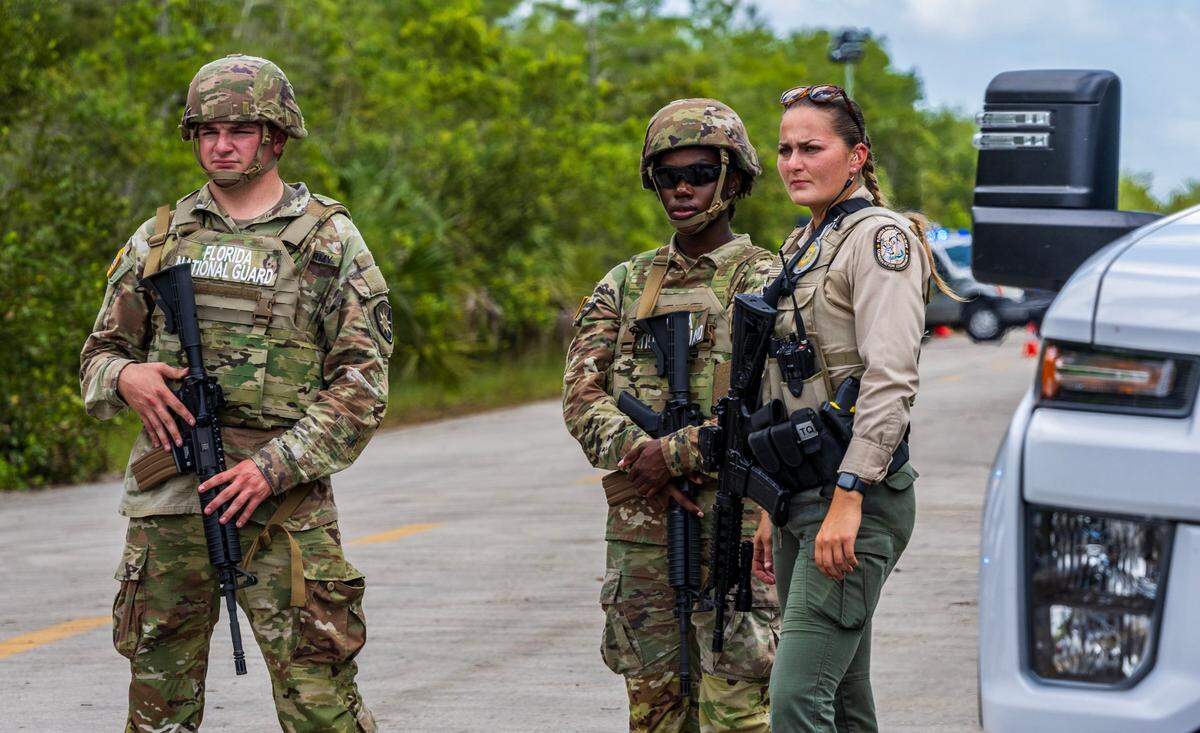 Florida National Guard members and a FWC officer keep guard as US President President Donald Trump and Florida Governor Ron DeSantis, toured the migrant detention center, dubbed “Alligator Alcatraz,” located at the site of the Dade-Collier Training and Transition Airport in Ochopee, Florida on July 1, 2025.