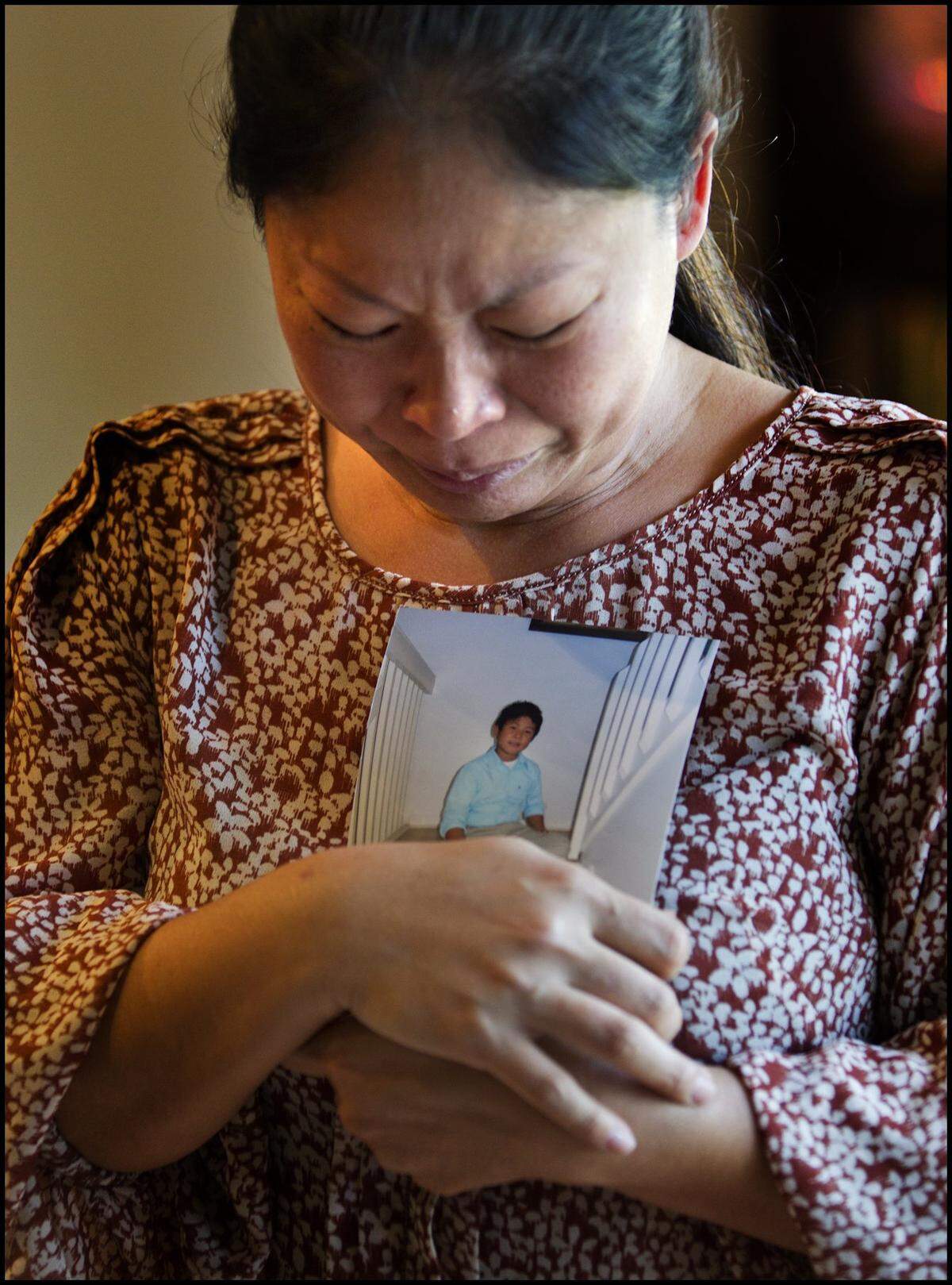 Lynn Ma grieves while holding a picture of her 10-year-old son Aaron Vu, who was shot and killed during a robbery at the family’s Hong Kong Nails salon in northwest Miami-Dade on Nov. 22, 2013. Lynn’s husband Hai Nam Vu was also shot during the robbery.