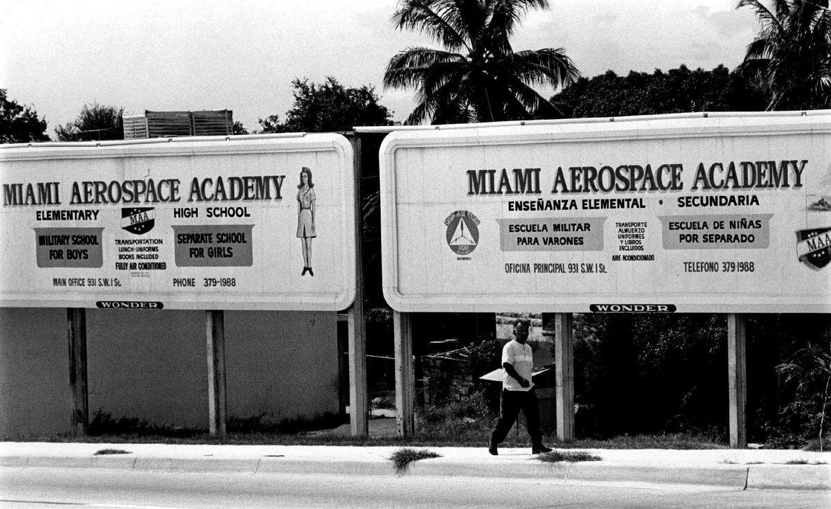 In 1971, the billboard on the left, on Flager Street in Miami carries an advertisement in English, while a twin on the right duplicates the message in Spanish.