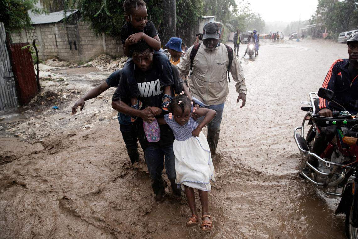 People walk through a flooded street following Hurricane Melissa in Petit-Goave, 68km southwest of Port-au-Prince, on October 30, 2025. 