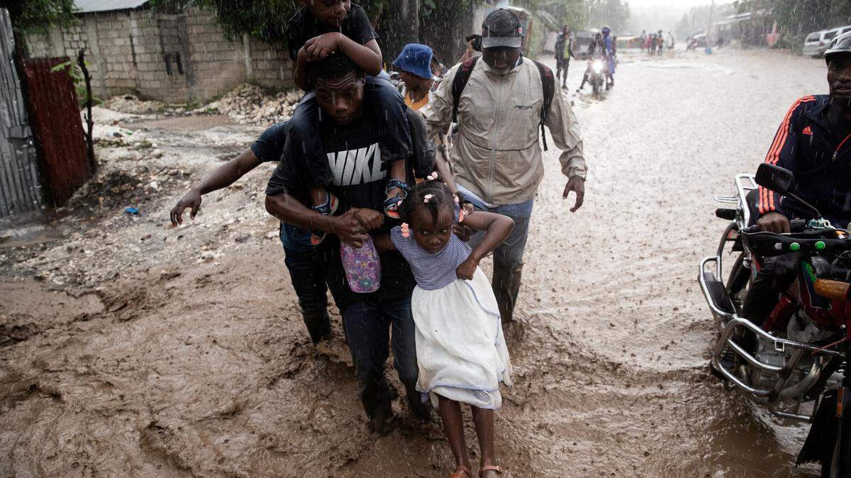 People walk through a flooded street following Hurricane Melissa in Petit-Goave, southwest of Port-au-Prince, on Oct. 30, 2025. 