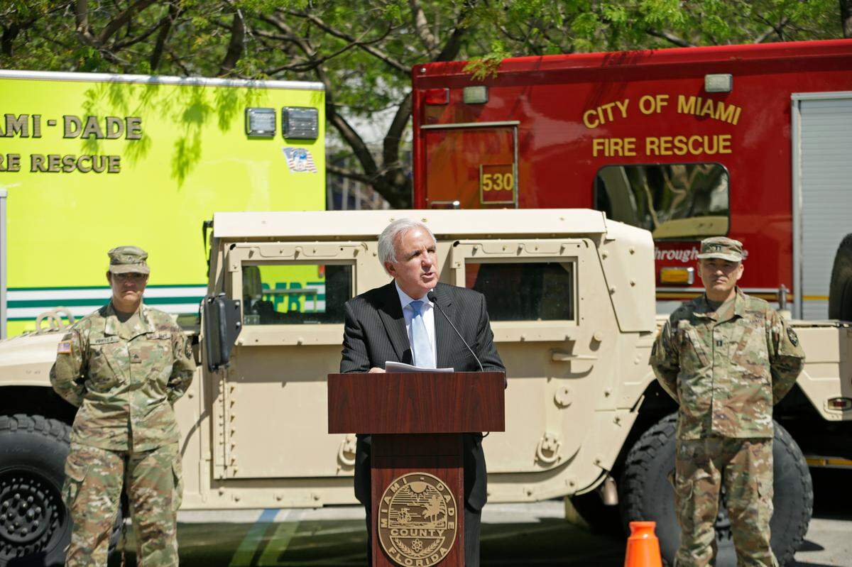 Miami-Dade County Mayor Carlos Gimenez leads a March 24, 2020 press conference at a new testing site at Marlins Park administered by the National Guard. The following day, he announced a “day of action” to enforce social distancing rules across the county.