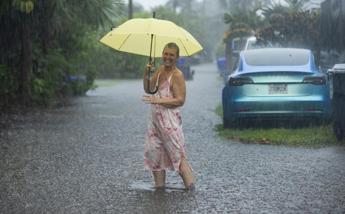 Laura Collinhofer holds an umbrella after moving her cars to higher ground after heavy rain flooded her neighborhood near the corner of Arthur Street and 14th Avenue on Wednesday, June 12, 2024, in Hollywood, Fla.