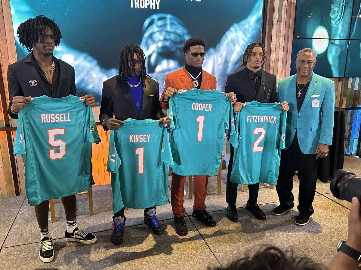 The Nat Moore Trophy finalists from left to right - Northwestern’s Calvin Russell Jr., Central’s Brandon Kinsey, Chaminade’s Derrek Cooper and St. Thomas Aquinas’ Justice Fitzpatrick - receive Miami Dolphins’ jerseys from Dolphins’ legend Nat Moore during a ceremony on Hard Rock Stadium on Dec. 2, 2025.