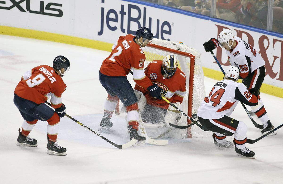 Ottawa Senators’ Oscar Lindberg (24) reaches for the puck with Magnus Paajarvi (56) as Florida Panthers goalkeeper Roberto Luongo (1), Jayce Hawryluk (8) and Josh Brown (2) defend during the first period of an NHL hockey game, Sunday, March 3, 2019, in Sunrise, Fla.