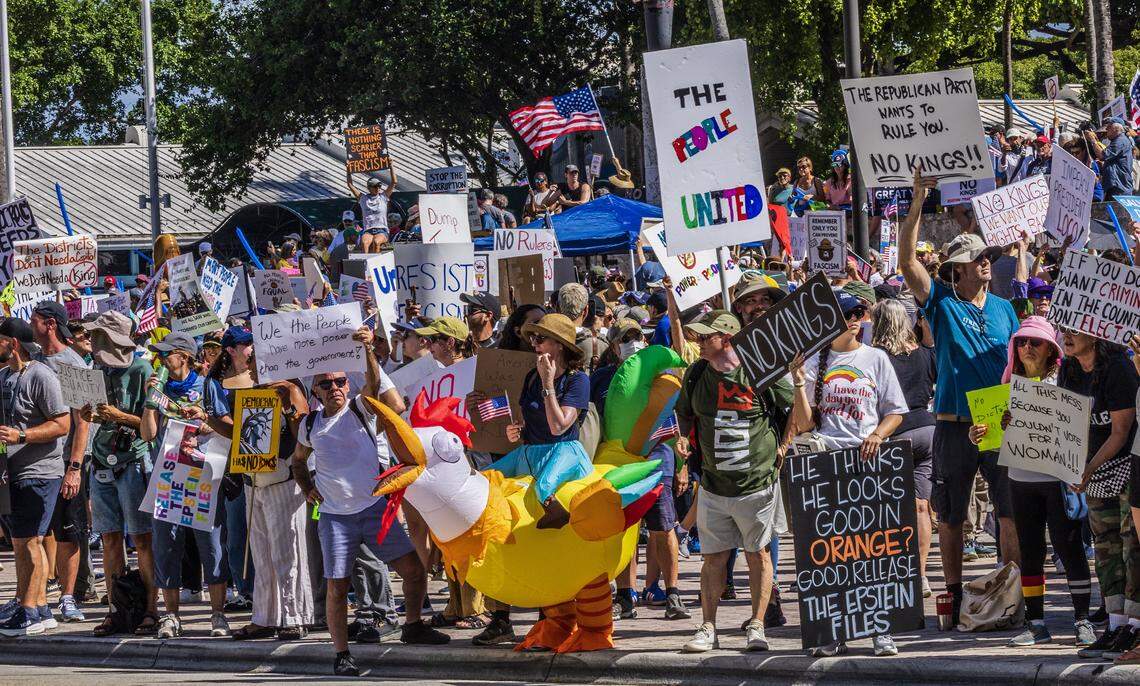 Protesters with signs at the Miami Torch of Friendship in downtown Miami during the ‘No Kings’ anti-Trump protests on Oct. 18, 2025.
