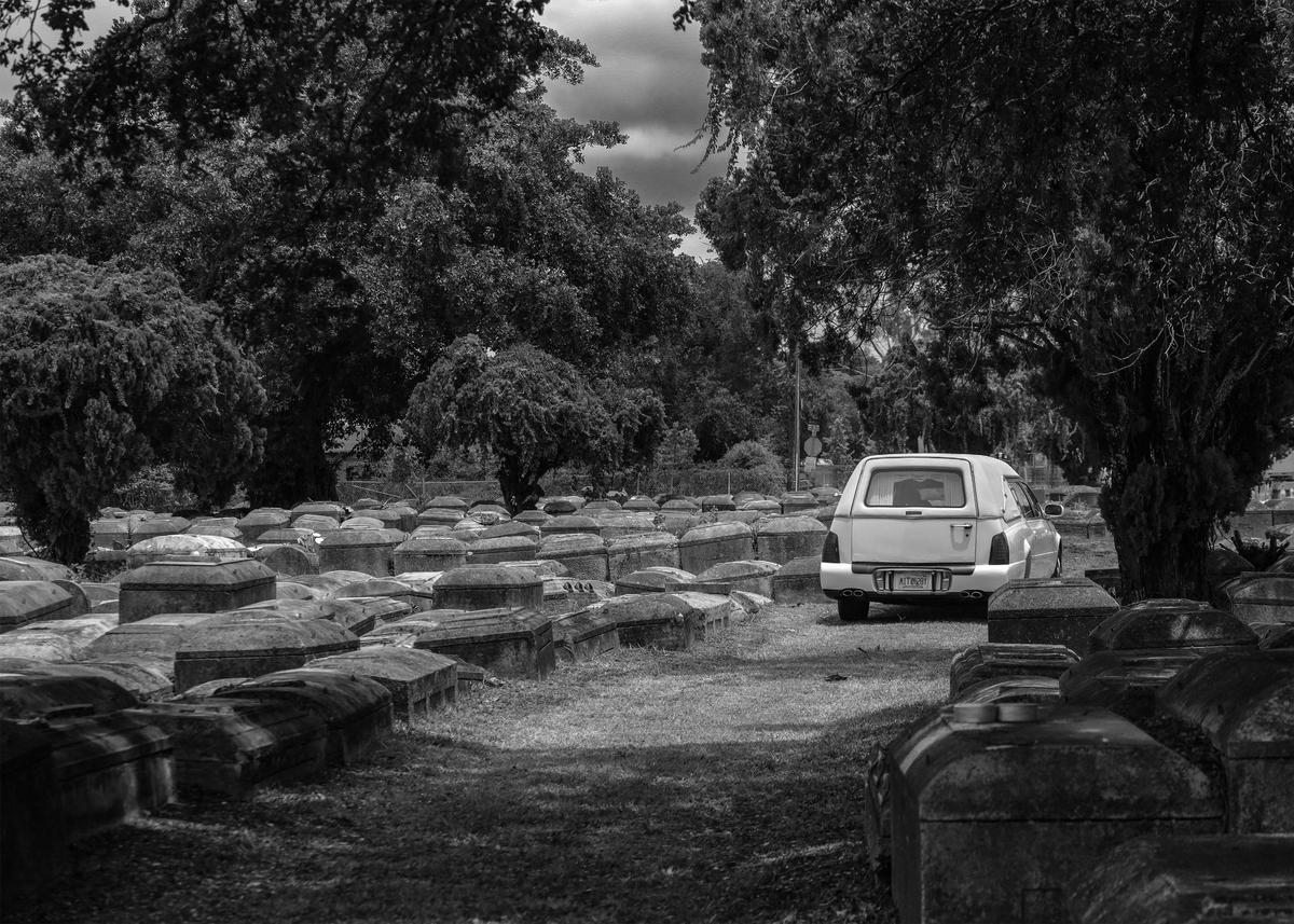 A white hearse exits Lincoln Memorial Park Cemetery in the Brownsville neighborhood.