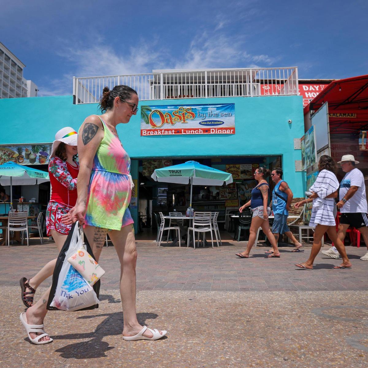 On Tuesday, May 30, 2023 police officers, tourists and locals mingle on the Hollywood Beach Broadwalk the day after a mass shooting left nine people injured. A witness recounts his efforts to help wounded people. --