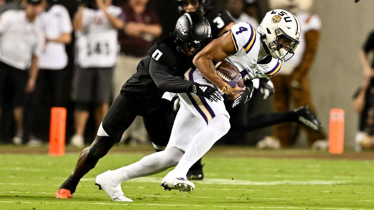 Oct 26, 2024; College Station, Texas, USA; LSU Tigers wide receiver CJ Daniels (4) catches a pass during the first quarter as Texas A&M Aggies linebacker Scooby Williams (0) defends at Kyle Field. Mandatory Credit: Maria Lysaker-Imagn Images.