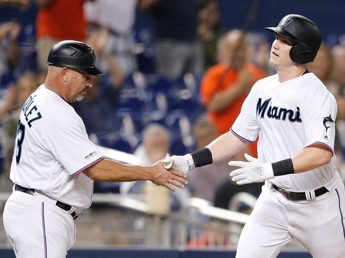 The Miami Marlins’ Garrett Cooper celebrates with third base coach Fredi Gonzalez after hitting a solo home run in the fifth inning against the Milwaukee Brewers on Wednesday, Sept. 11, 2019, at Marlins Park.